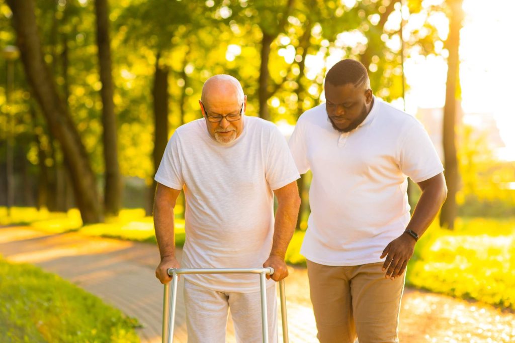 Elderly man using walker outdoors