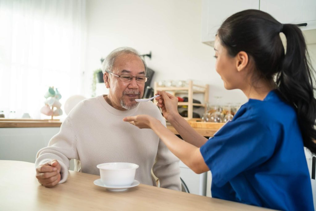 Feeding older man with spoon